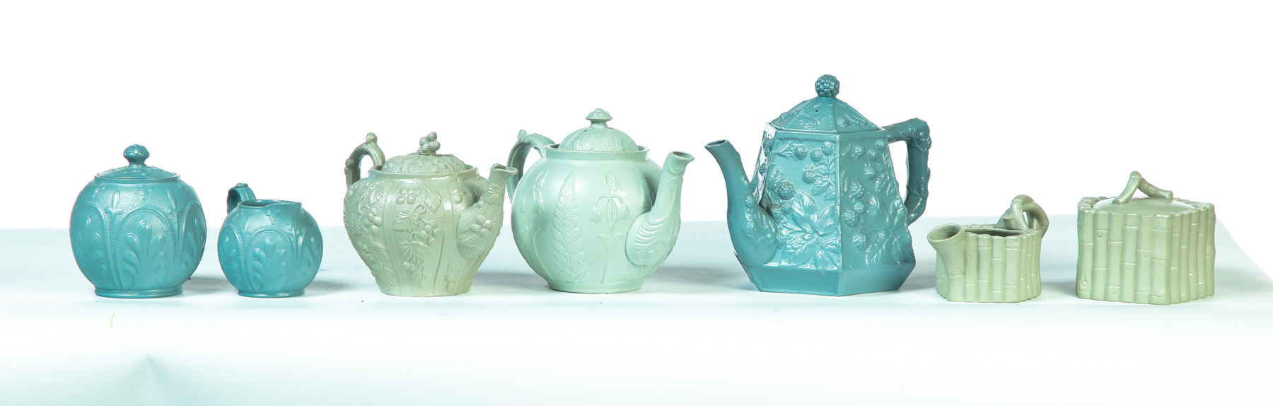 Appraisal: SEVEN RELIEF MOLDED GREEN TEAPOTS CREAMERS AND SUGARS England mid