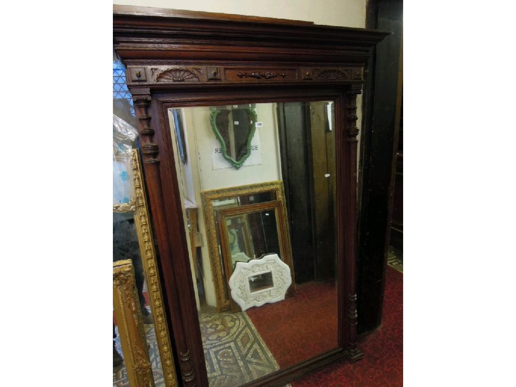 Appraisal: A large continental oak framed wall mirror with bevelled edge