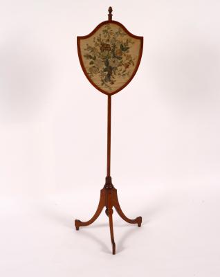 Appraisal: A satinwood pole screen the shield-shaped needlework banner on a