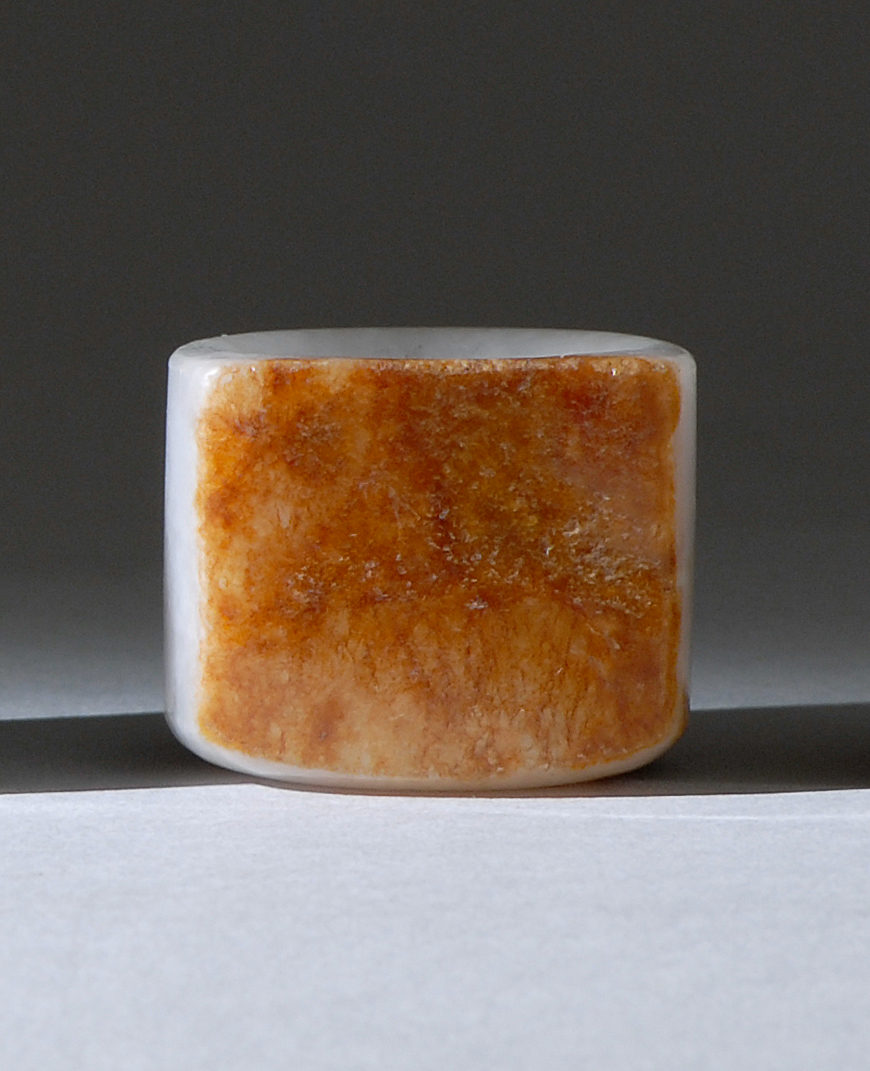 Appraisal: WHITE AND RUSSET JADE ARCHER'S RING th CenturyWith flattened russet