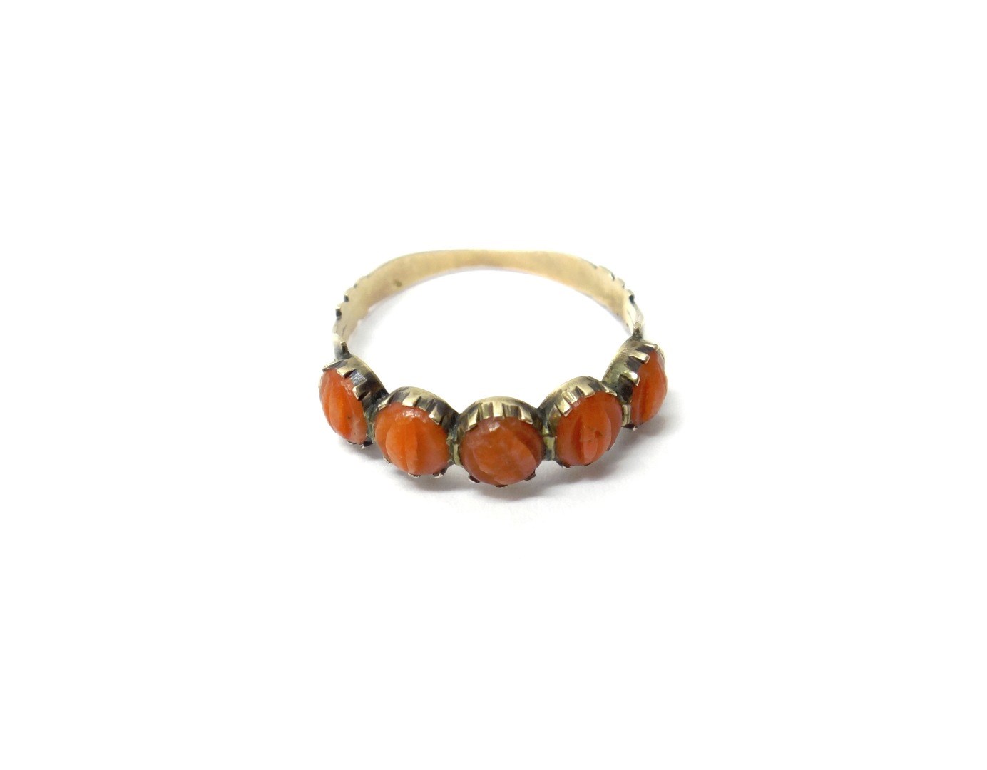 Appraisal: A gold and coral ring mounted with a row of