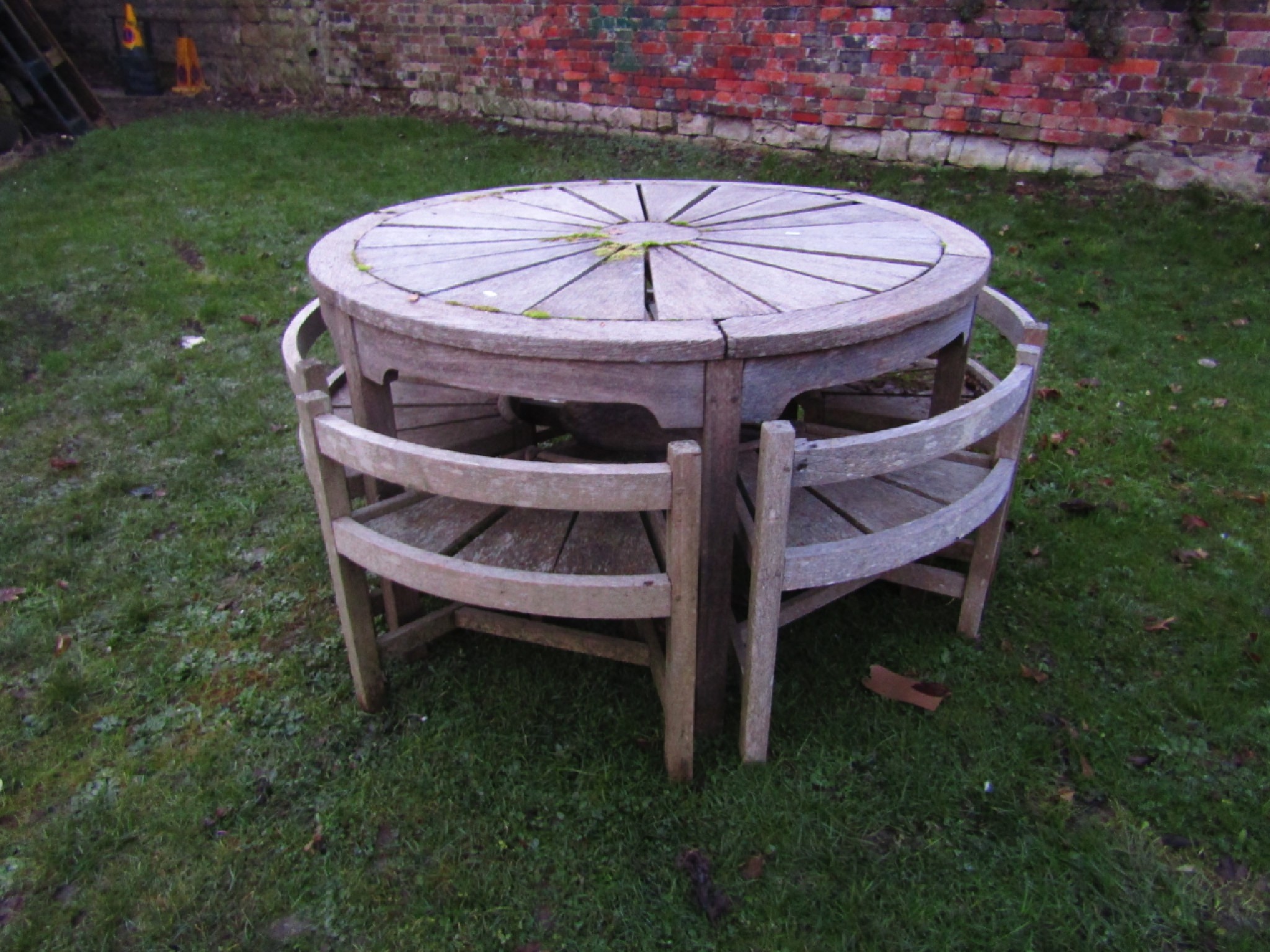 Appraisal: A weathered teak garden table of circular form in the