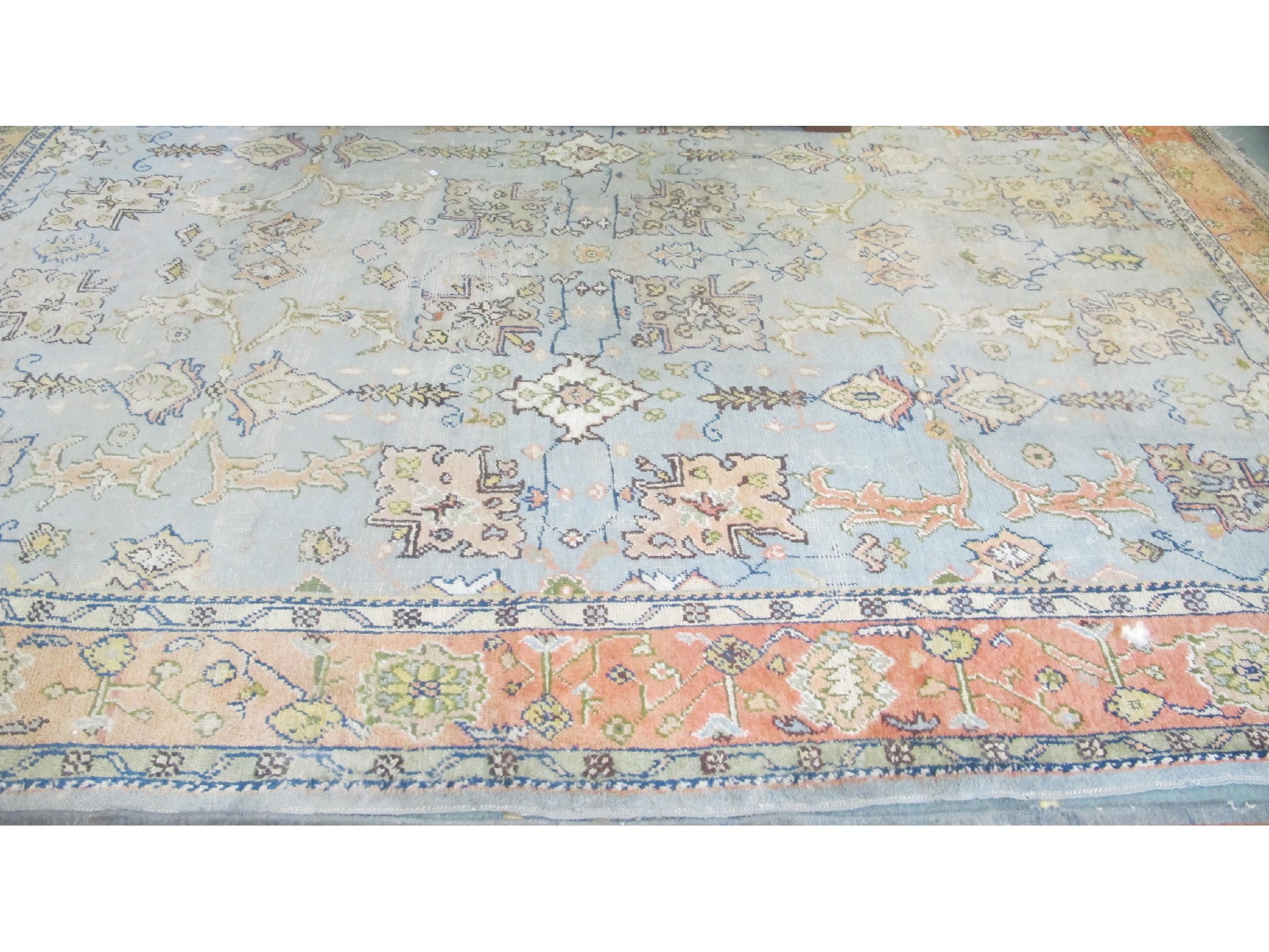 Appraisal: A large floral rug on a blue and pink ground