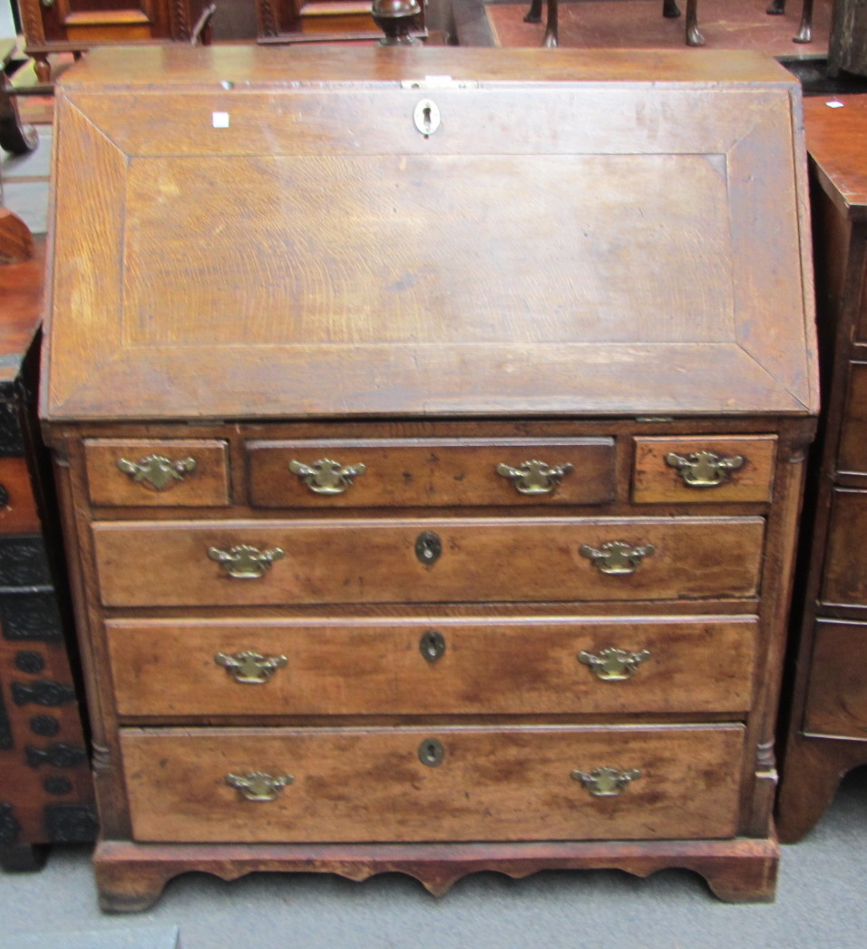 Appraisal: A mid th century oak bureau the fall enclosing a