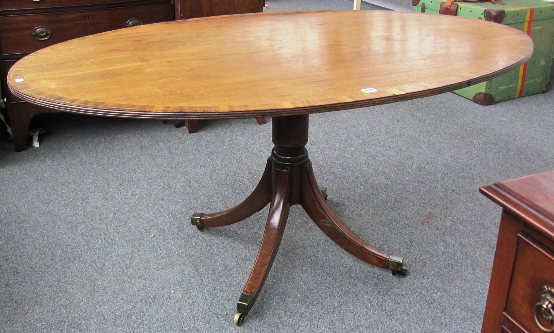 Appraisal: A George III crossbanded oval mahogany snap top breakfast table