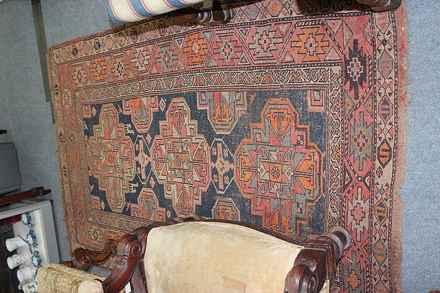 Appraisal: A MIDDLE EASTERN RED GROUND RUG with multiple banded border