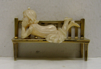 Appraisal: CARVED IVORY MINIATURE FIGURE OF A GIRL Resting on a