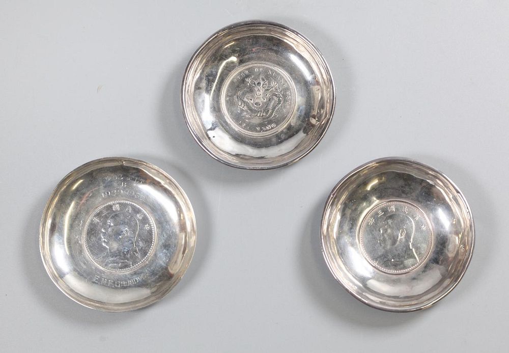 Appraisal: Chinese silver coins inlaid in silver dishes each overall in