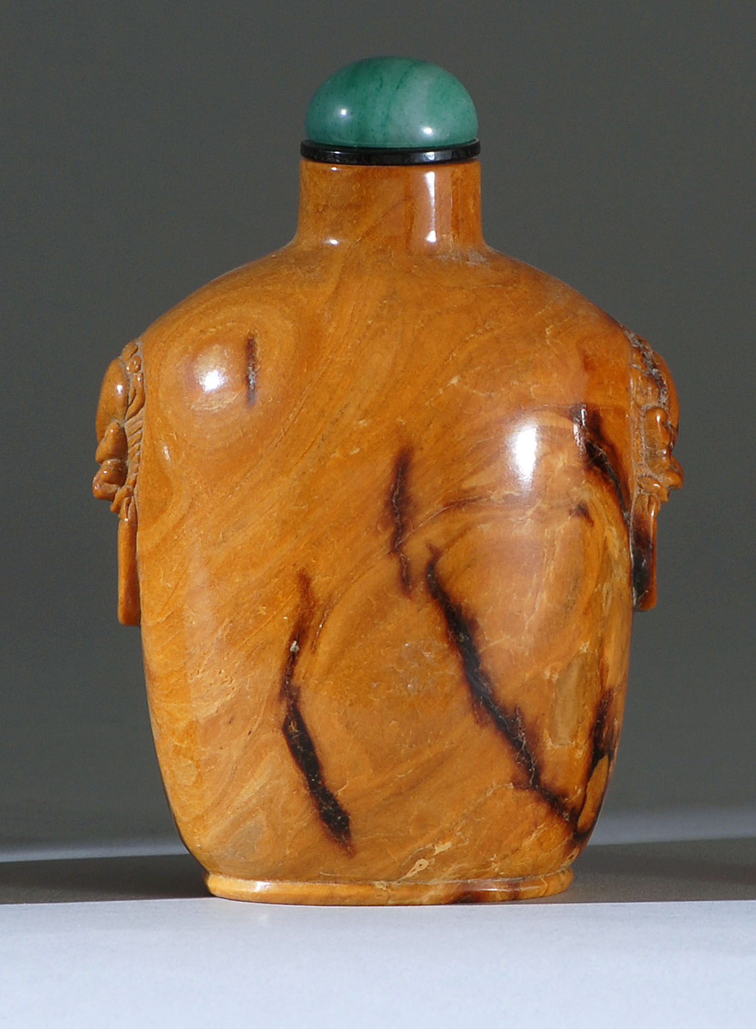 Appraisal: HONEY AMBER SNUFF BOTTLE th CenturyIn spade shape with mask