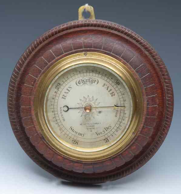 Appraisal: A CIRCULAR OAK CASED ANEROID BAROMETER by Negretti Zambra of