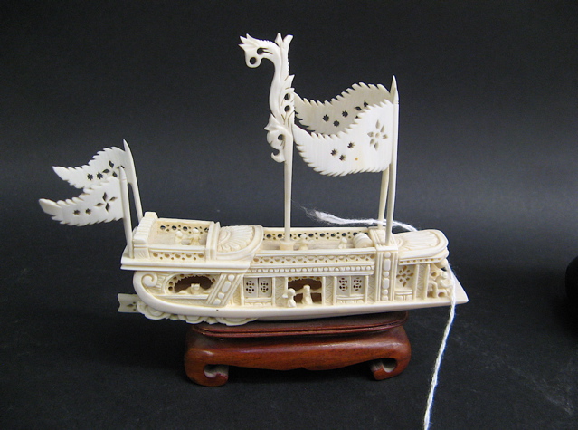 Appraisal: IVORY HAND CARVED MINIATURE CHINESE BOAT having pierced pennants and