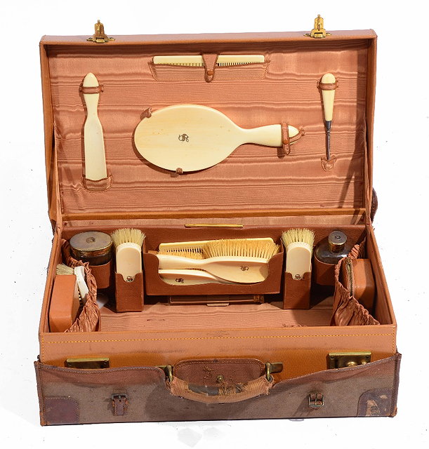 Appraisal: A LEATHER BOUND TRAVELLING SUITCASE with ivory back hairbrushes mirrors