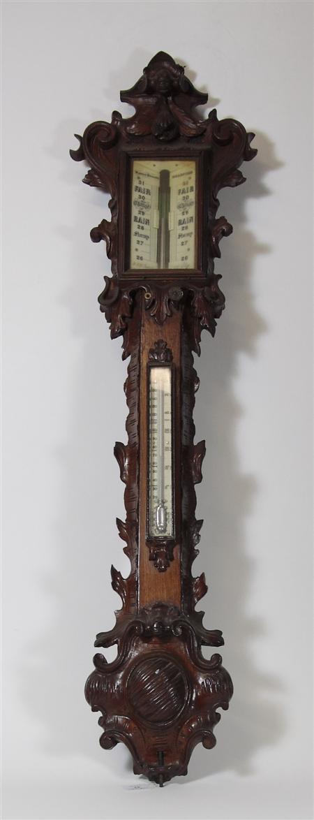 Appraisal: A carved oak stick barometer The dial marked Manoah Rhoades