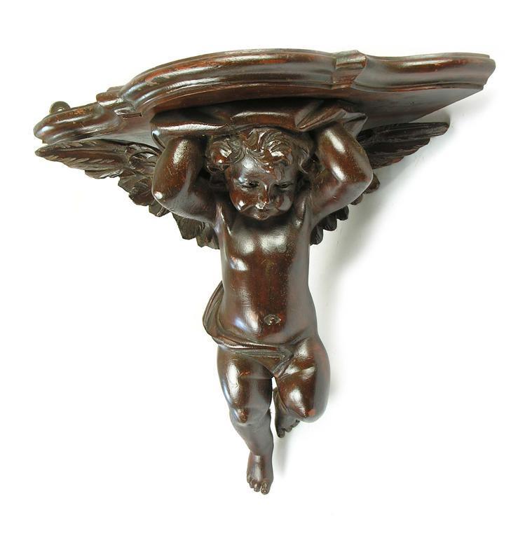 Appraisal: A th century carved wood and painted cherub corner bracket