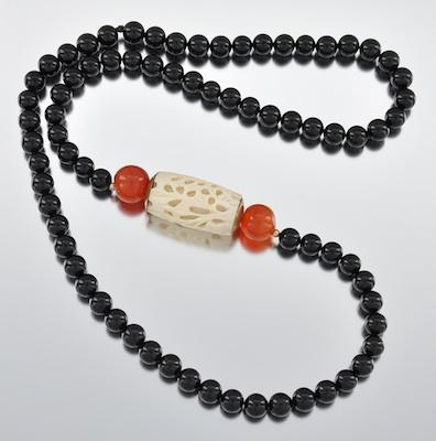 Appraisal: An Onyx Agate and Carved Ivory Necklace The necklace is