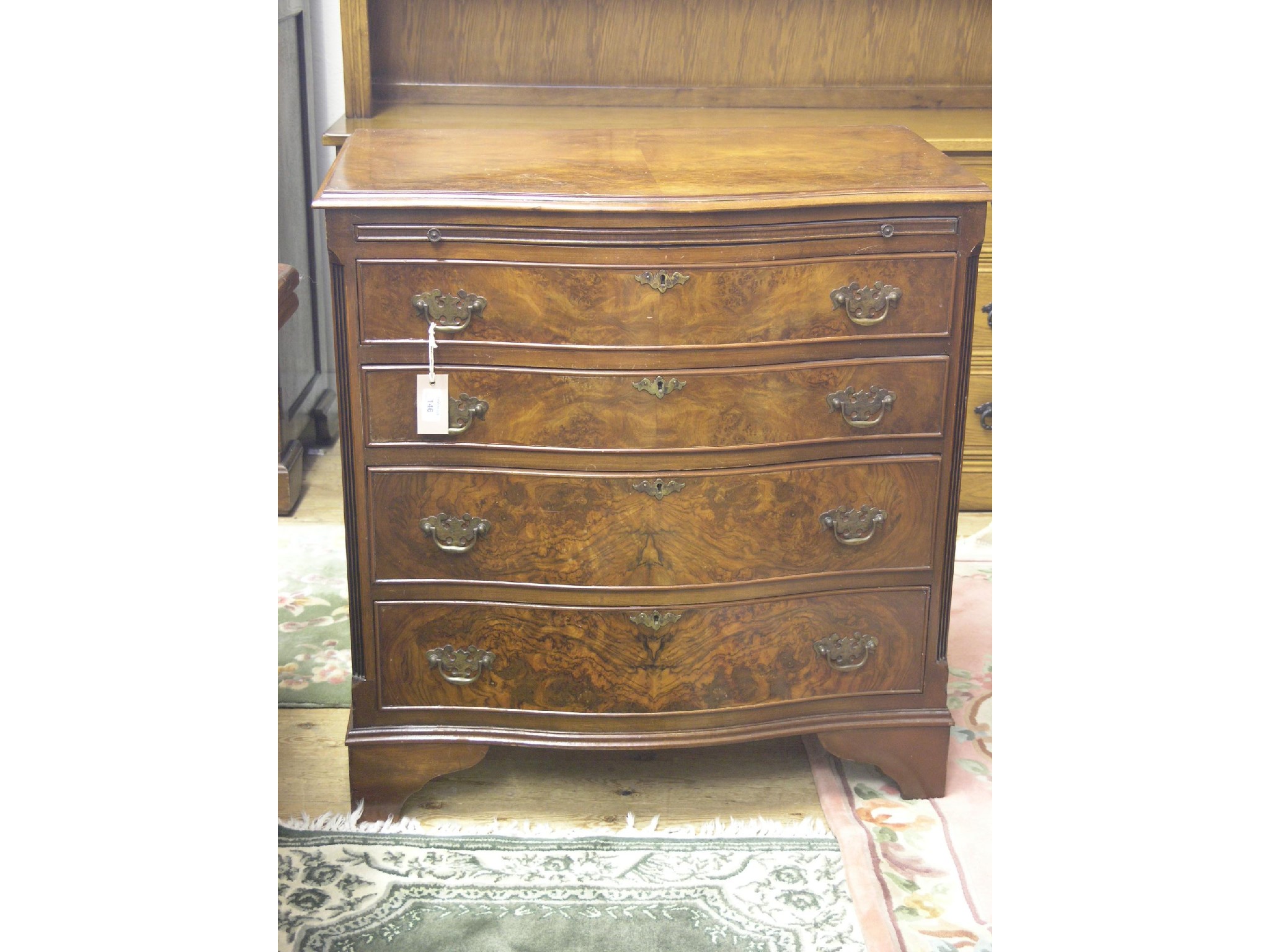 Appraisal: A reproduction burr walnut chest serpentine-fronted with brushing slide four