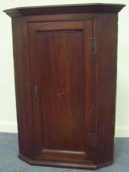 Appraisal: A mid th Century oak corner cupboard with fitted shaped