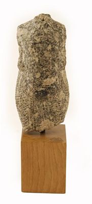 Appraisal: A carved quartzite male torso wearing a striated skirt wrapped