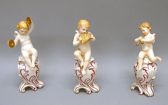 Appraisal: Each seated on leaf-molded urn one playing panpipes second playing