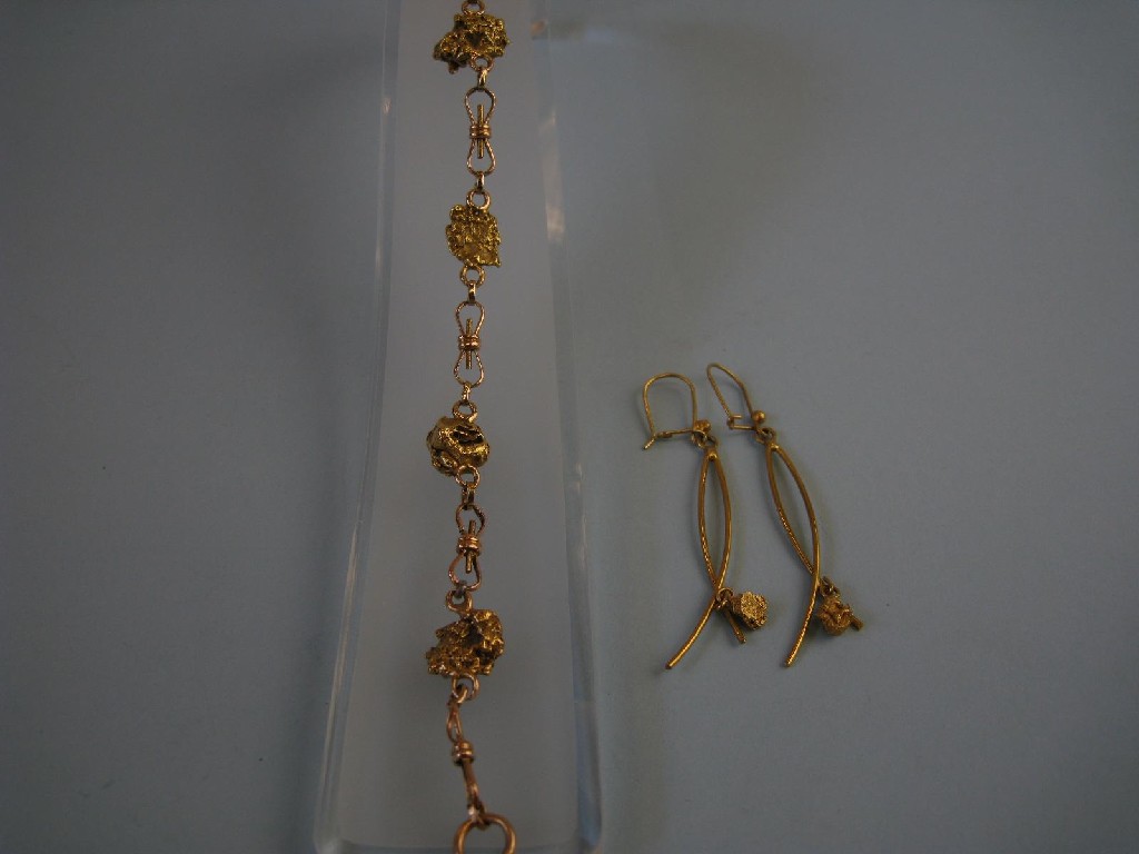 Appraisal: A gold Bracelet with bow links interspersed with nuggets and