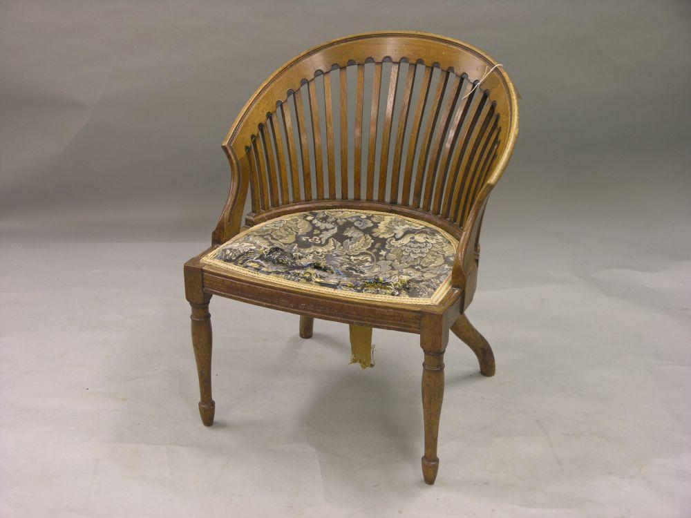 Appraisal: A late Victorian solid walnut tub shape nursing armchair with