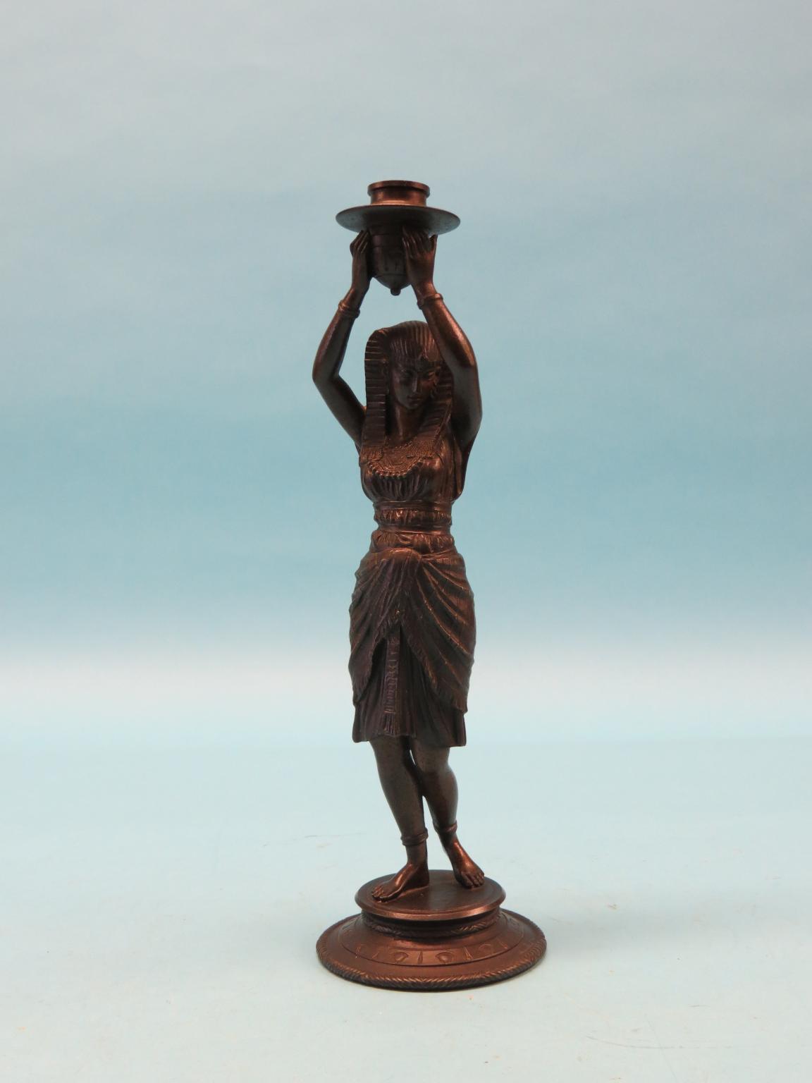 Appraisal: A bronzed spelter candlestick figure Egyptian female holding sconce aloft