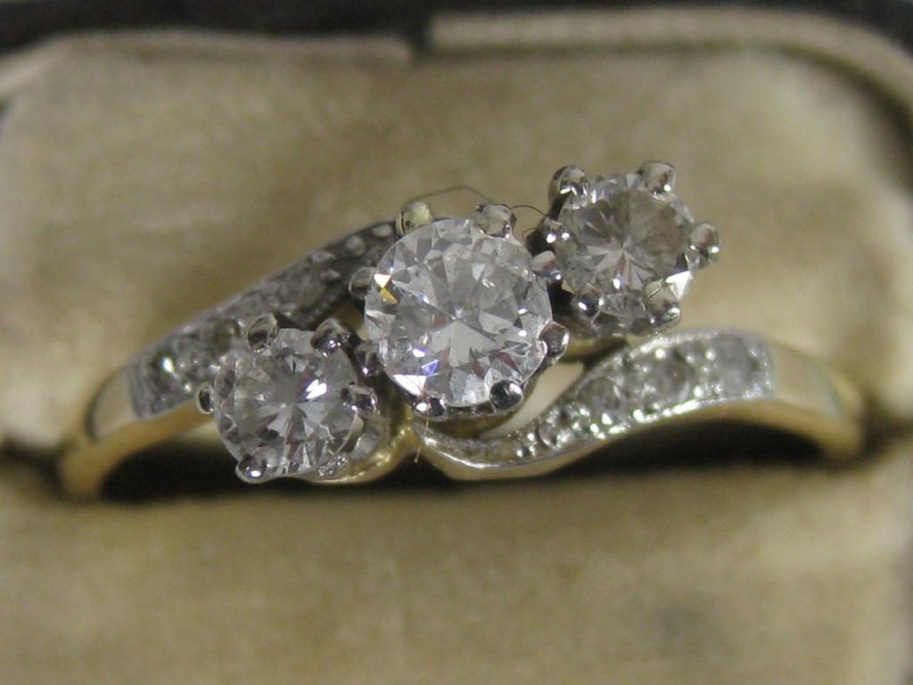 Appraisal: A three stone Diamond Crossover Ring the circular-cut graduated stones