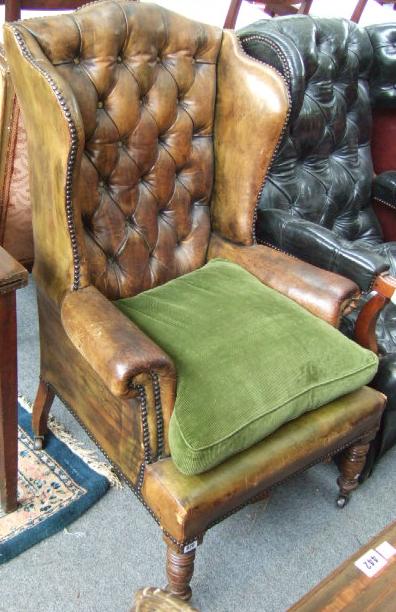 Appraisal: A Victorian mahogany and green buttoned leather armchair on turned