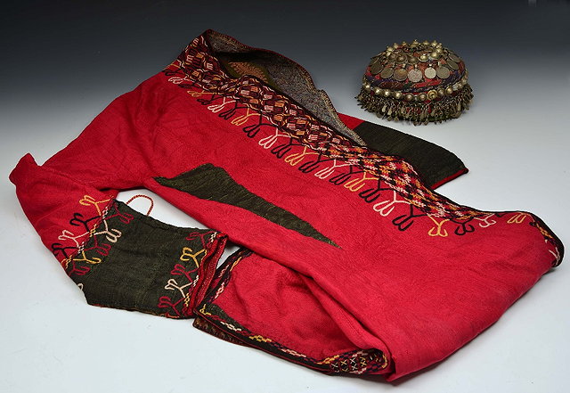 Appraisal: A TURKOMAN EMBROIDERED BURGUNDY COLOURED COAT and an Uzbekistan cap