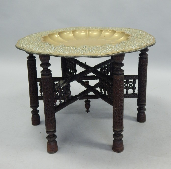 Appraisal: An Eastern occasional table the embossed brass circular top with