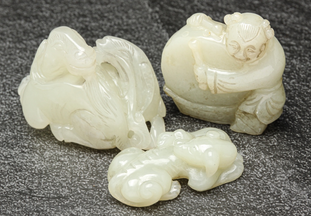 Appraisal: THREE CHINESE WHITE JADE CARVINGS Twentieth century Drummer h goats