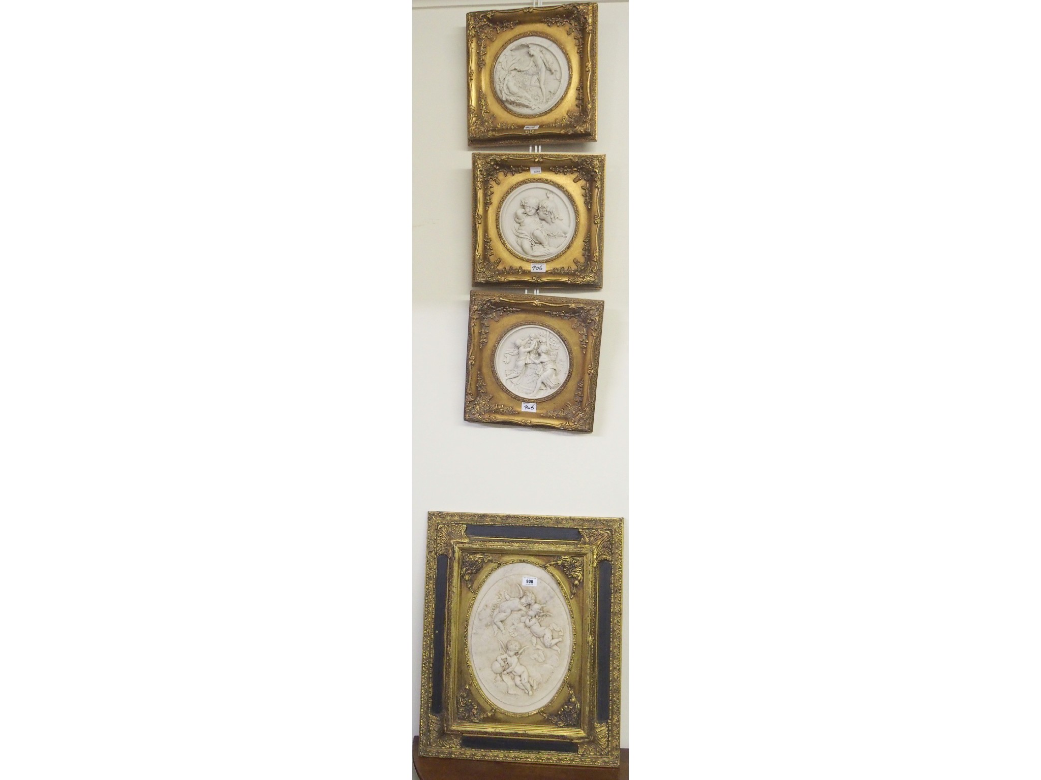 Appraisal: A set of three gilt wall plaques and a larger