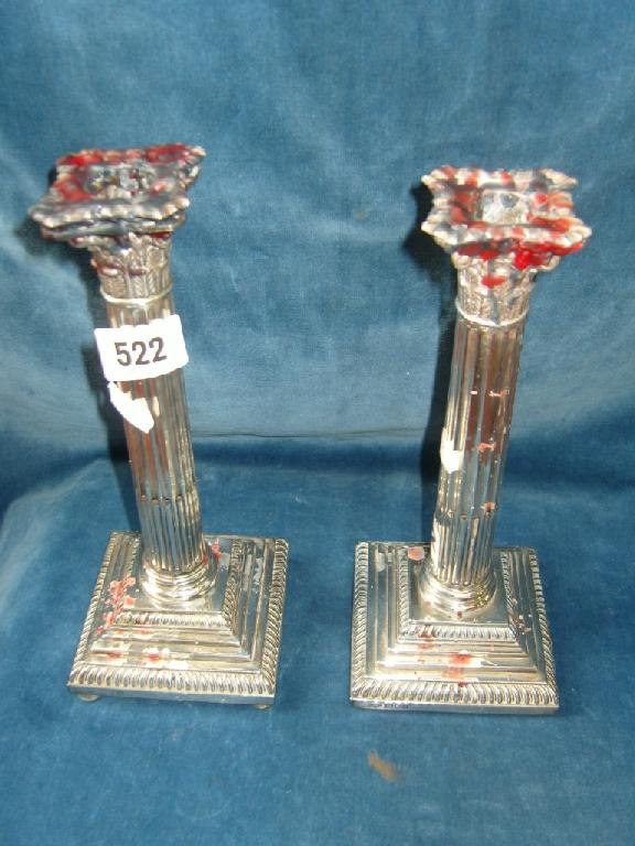 Appraisal: A pair of silver Corinthian column candlesticks on stepped square