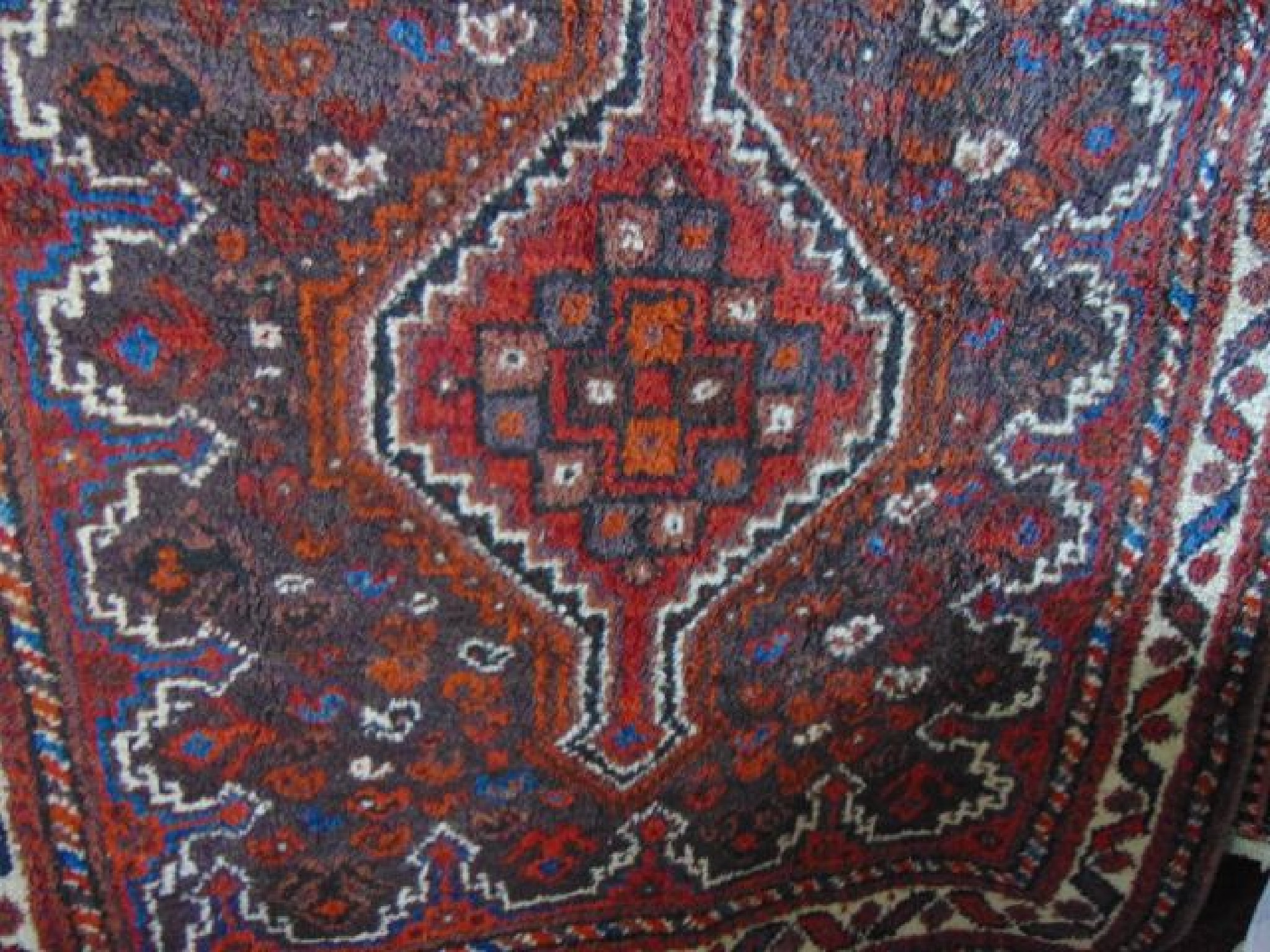 Appraisal: A Persian wool rug with multi medallion centre upon a