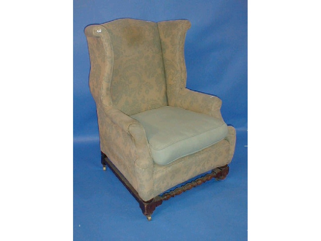 Appraisal: A heavy oak framed high backed wing armchair in the