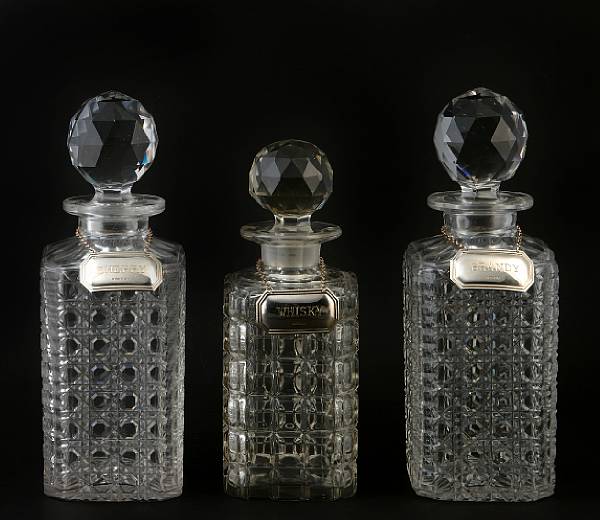 Appraisal: A group of three cut glass decanters with later sterling