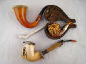 Appraisal: A display case containing three meerschaum pipes and a small