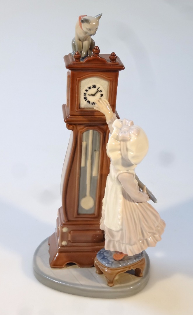 Appraisal: A Lladro figure of a girl aside longcase clock headed