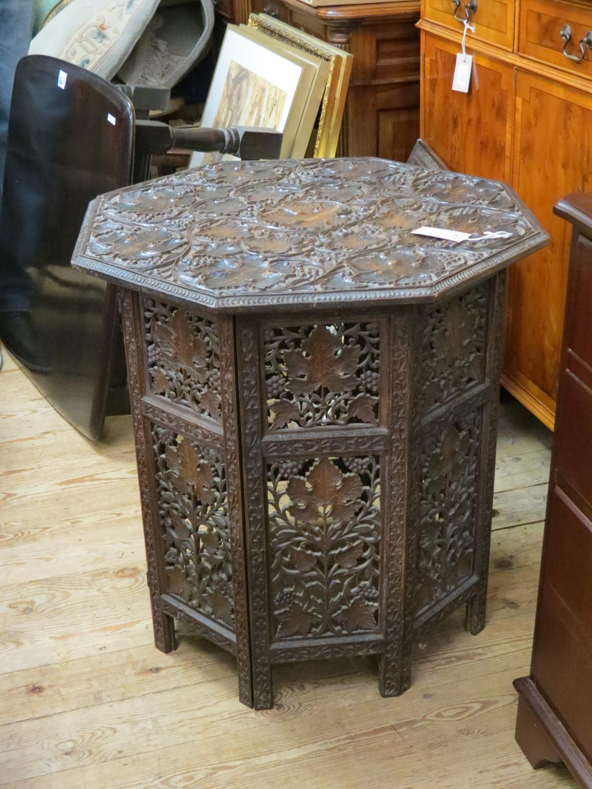 Appraisal: An Eastern octagonal centre table profusely carved with grape-vines ft