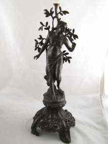 Appraisal: A spelter figure of a woman on an ornate rococo