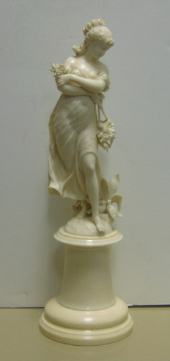 Appraisal: CONTINENTAL CARVED IVORY FEMALE FIGURE Classical figure walking with basket