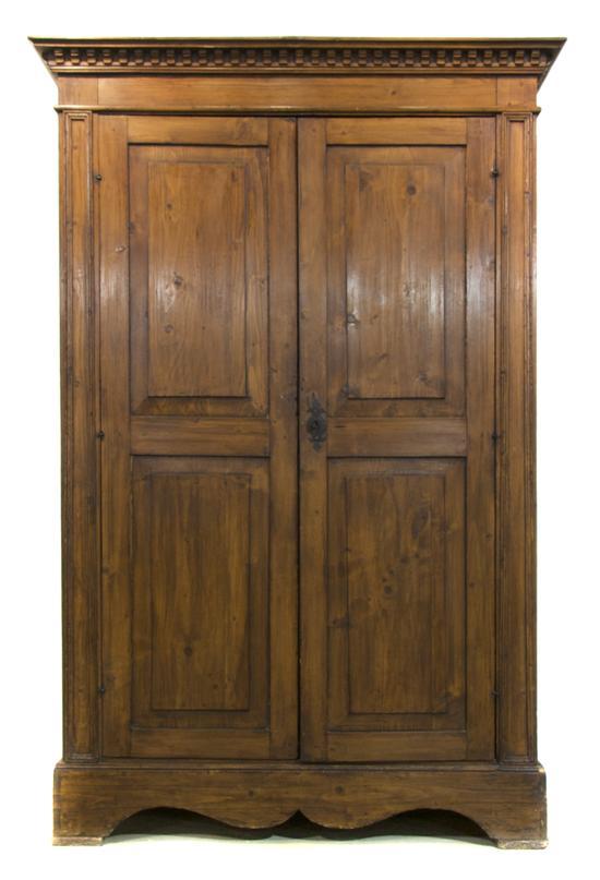 Appraisal: A Continental Fruitwood Armoire having a dentiled cornice over two