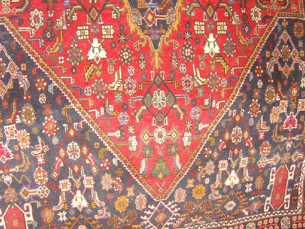 Appraisal: A red ground eastern wool rug with polychrome stylised floral