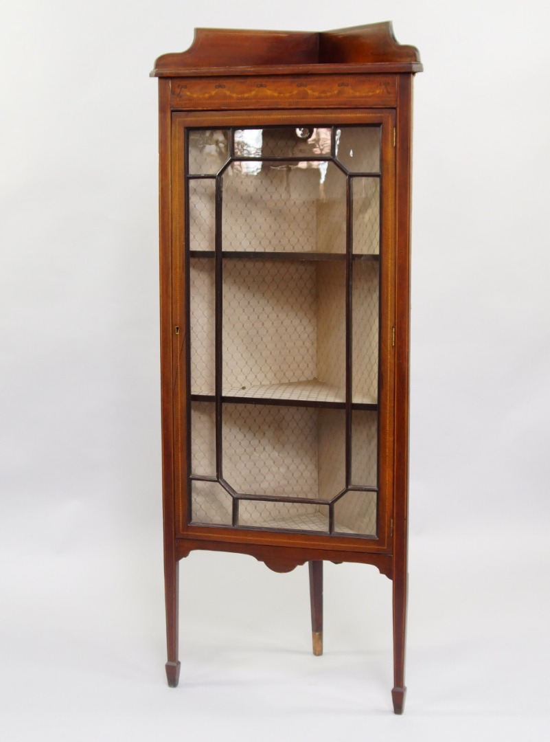 Appraisal: An Edwardian mahogany and satinwood inlaid corner display cabinet glazed