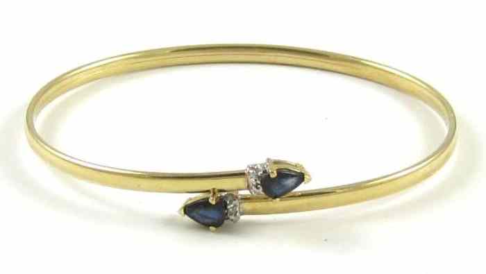 Appraisal: SAPPHIRE DIAMOND AND FOURTEEN KARAT GOLD BANGLE set with two