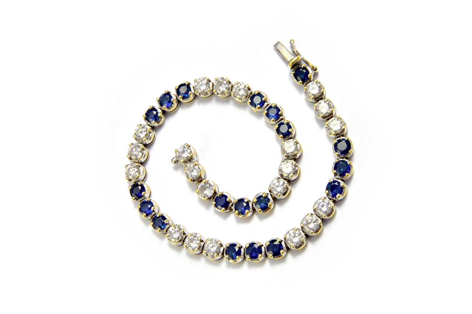 Appraisal: A gold sapphire and diamond set line bracelet claw set