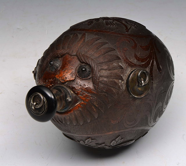 Appraisal: A TH CENTURY CARVED NUT FLASK with mask spout hunting