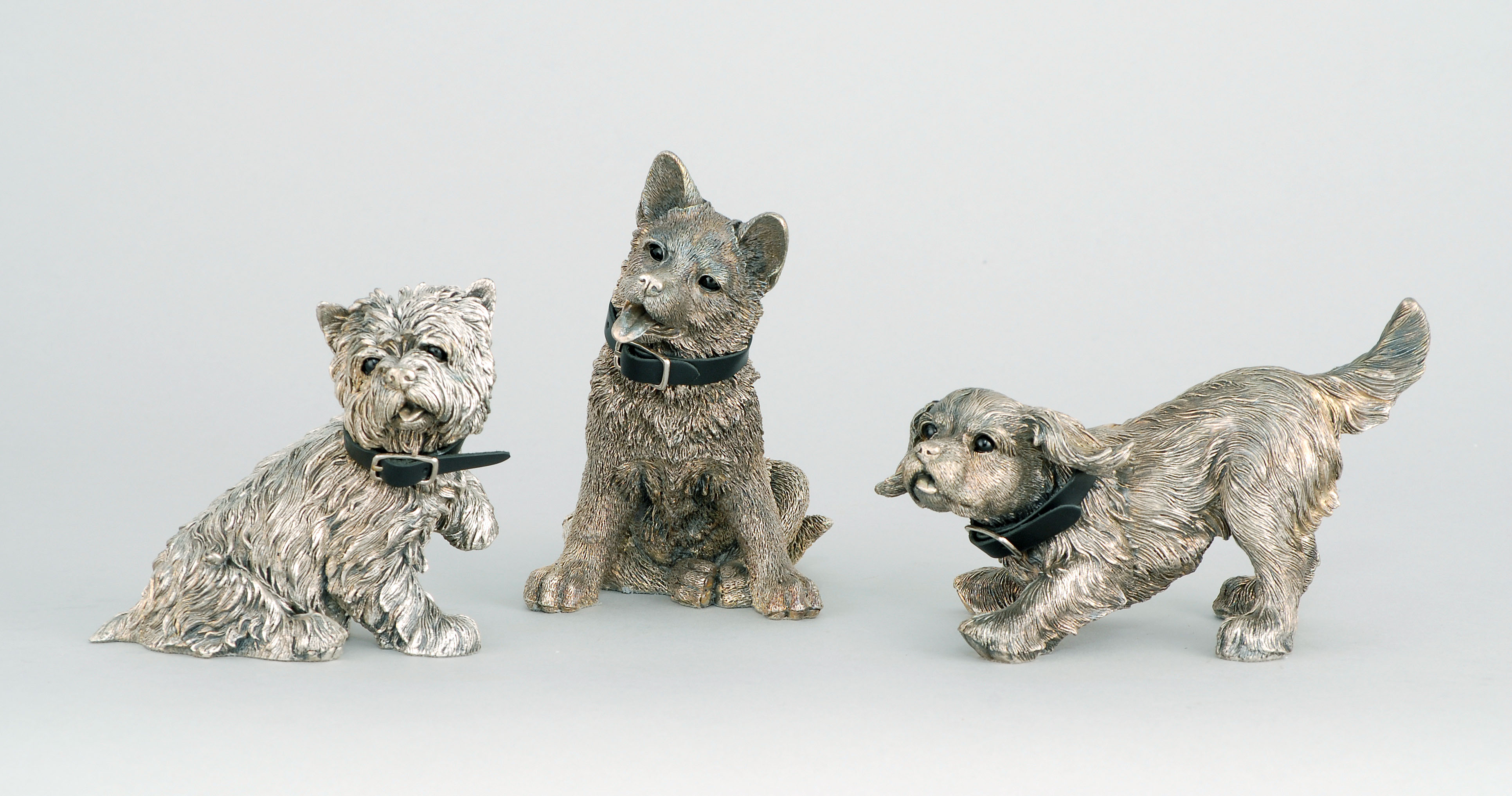 Appraisal: THREE COMYNS OF LONDON FILLED SILVER PUPPY DOG FIGURES Late