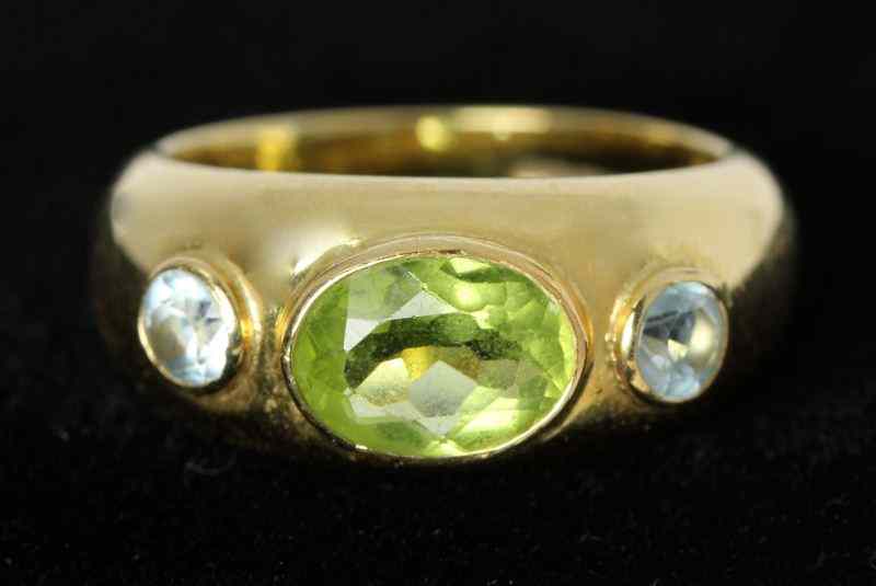 Appraisal: Peridot and Topaz Ringcentering on one bezel set oval cut