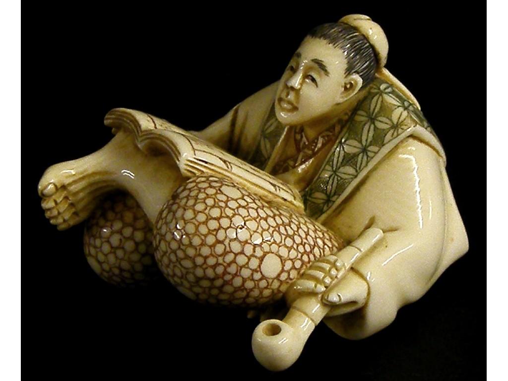 Appraisal: Japanese carved ivory okimono modelled as a seated man holding